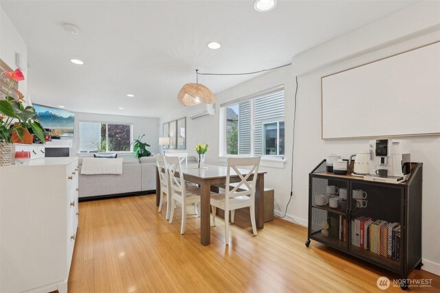 dining area with an AC wall unit, recessed lighting, and light wood-style floors