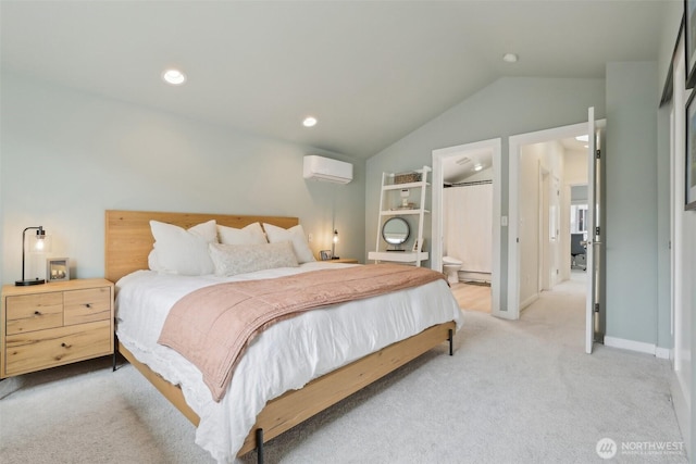 bedroom with light carpet, lofted ceiling, a wall unit AC, connected bathroom, and baseboards
