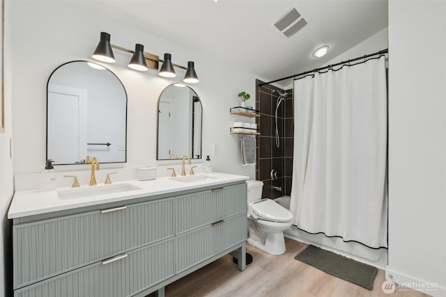 full bathroom with toilet, wood finished floors, double vanity, shower / bath combination with curtain, and vaulted ceiling