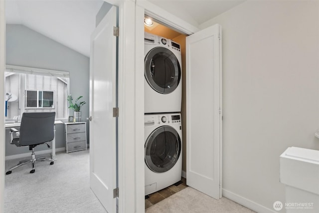 laundry area featuring stacked washer / dryer, baseboards, an office area, and carpet flooring