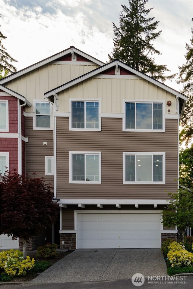 view of front of property with a garage, board and batten siding, concrete driveway, and stone siding