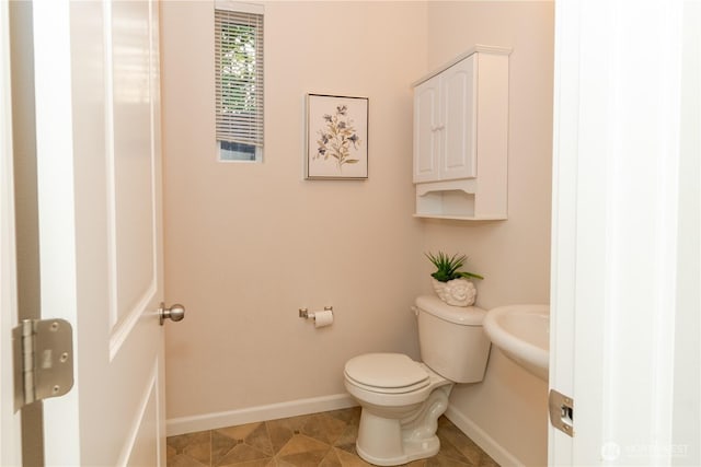 bathroom featuring baseboards and toilet