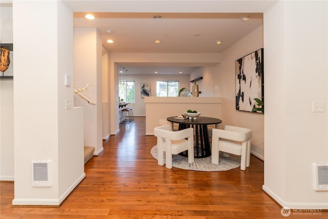 corridor with light wood-style floors, baseboards, and recessed lighting