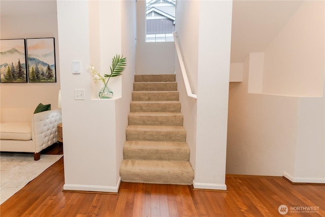 staircase with wood finished floors and baseboards
