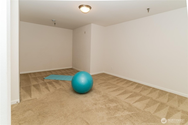 workout area featuring carpet and baseboards