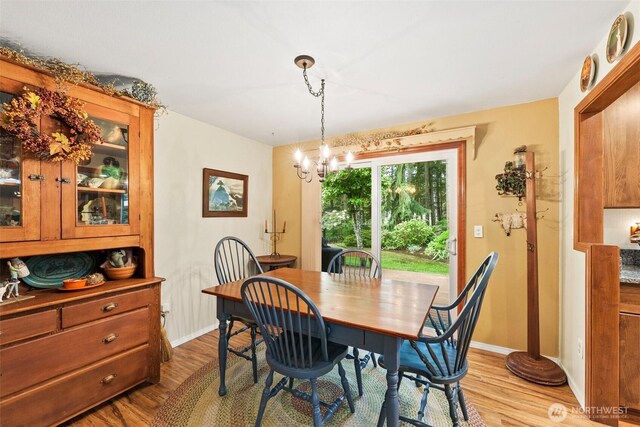2124 213th Street Ct E, Spanaway, WA 98387 - dining area featuring wood finished floors, a chandelier, and baseboards