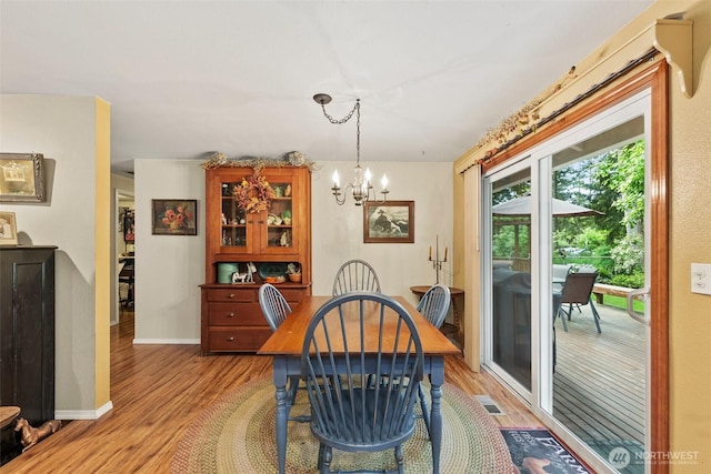 2124 213th Street Ct E, Spanaway, WA 98387 - dining area with light wood-type flooring, a chandelier, and baseboards