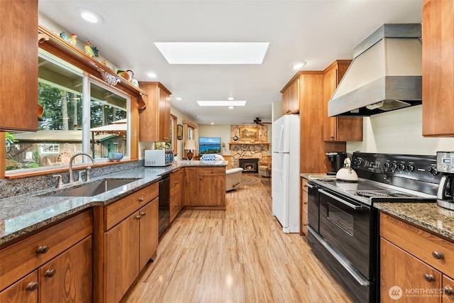 2124 213th Street Ct E, Spanaway, WA 98387 - kitchen featuring black appliances, custom range hood, a skylight, light wood-type flooring, and a sink