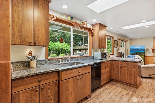 2124 213th Street Ct E, Spanaway, WA 98387 - kitchen with a skylight, dishwasher, a sink, light wood-style floors, and a peninsula