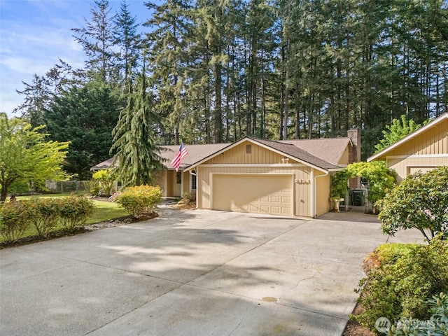 2124 213th Street Ct E, Spanaway, WA 98387 - view of front of house with an attached garage, a chimney, concrete driveway, and roof with shingles