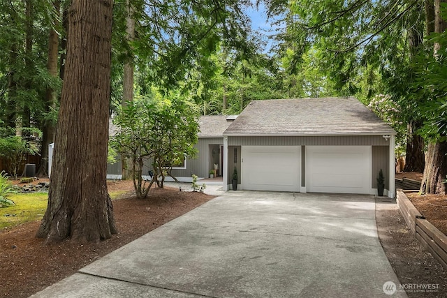 view of front of home with roof with shingles, driveway, and an attached garage