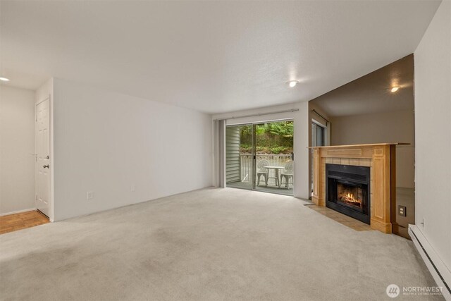 4106 Factoria Blvd SE Unit 216, Bellevue, WA 98006 - unfurnished living room featuring a baseboard radiator, carpet flooring, and a fireplace