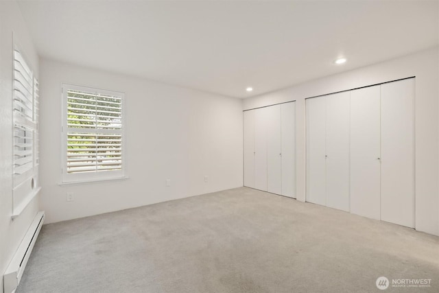 4106 Factoria Blvd SE Unit 216, Bellevue, WA 98006 - unfurnished bedroom featuring baseboard heating, two closets, carpet, and recessed lighting