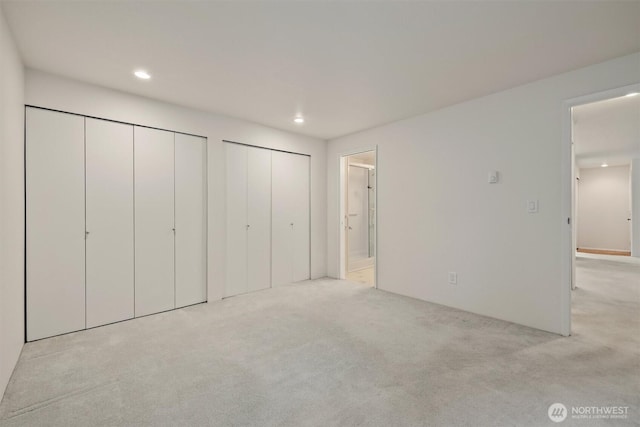 4106 Factoria Blvd SE Unit 216, Bellevue, WA 98006 - unfurnished bedroom featuring multiple closets, carpet flooring, recessed lighting, and ensuite bath
