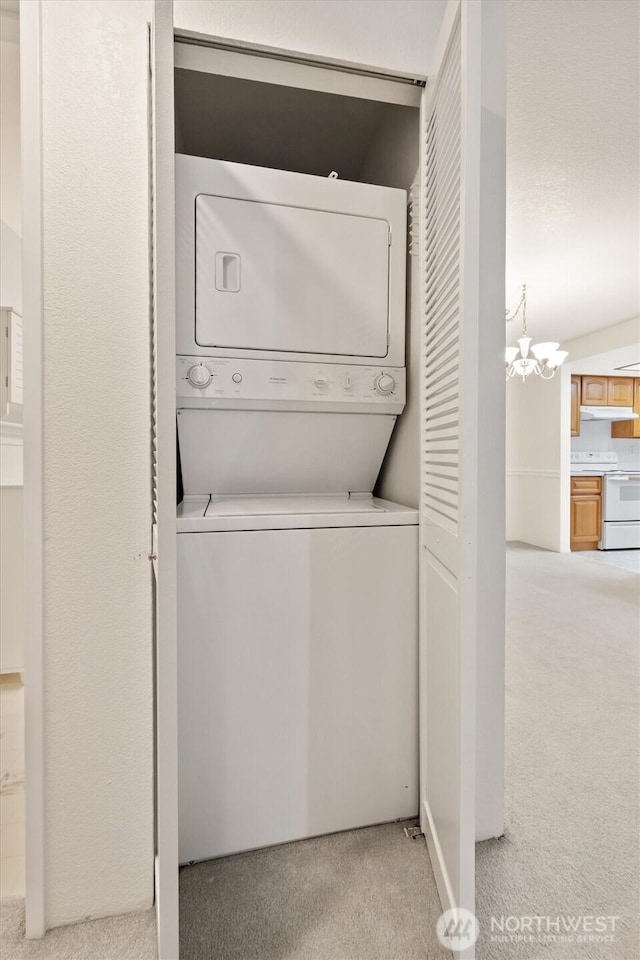 4106 Factoria Blvd SE Unit 216, Bellevue, WA 98006 - washroom featuring carpet flooring, stacked washing machine and dryer, and a chandelier