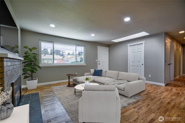 10910 114th Ave SW, Tacoma, WA 98498 - living room with a skylight, a fireplace, wood finished floors, recessed lighting, and baseboards