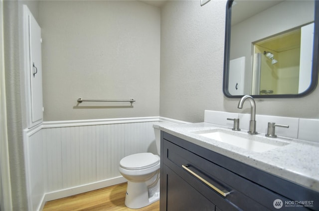 10910 114th Ave SW, Tacoma, WA 98498 - bathroom featuring wainscoting, wood finished floors, vanity, and toilet
