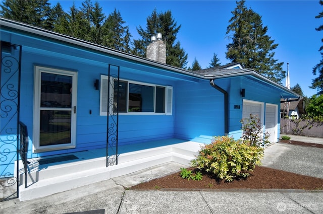 10910 114th Ave SW, Tacoma, WA 98498 - view of front of home with a porch, an attached garage, a chimney, and driveway