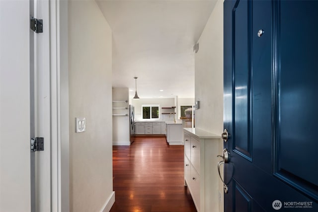 foyer with dark wood finished floors and baseboards