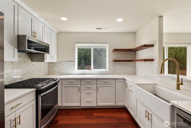 kitchen with stainless steel appliances, a sink, plenty of natural light, light countertops, and recessed lighting