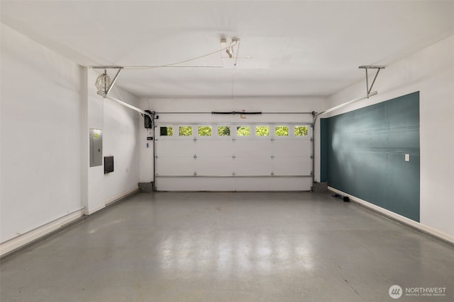 garage featuring electric panel and baseboards