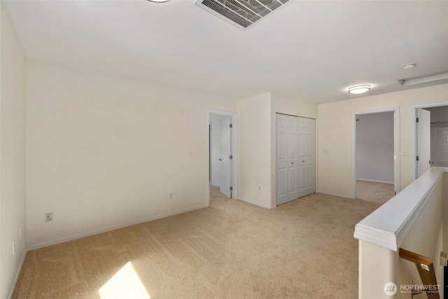 spare room featuring light colored carpet, baseboards, and a smoke detector