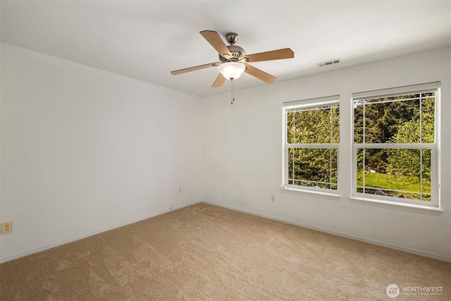 unfurnished room featuring light colored carpet, baseboards, and ceiling fan