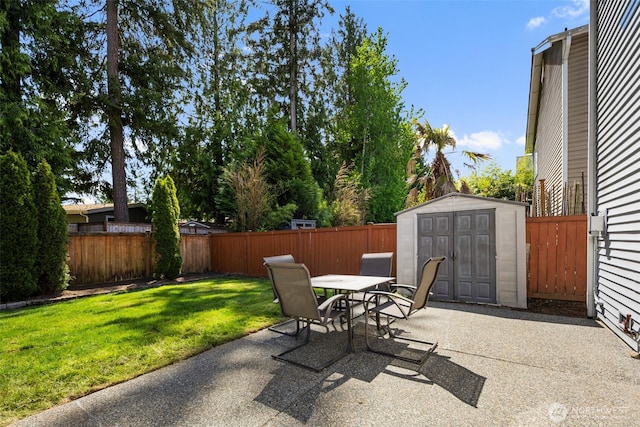 view of patio featuring outdoor dining space, a shed, and an outbuilding