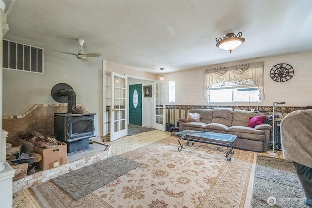 12623 Douglas Rd, Yakima, WA 98908 - living room featuring a wood stove, a ceiling fan, and french doors