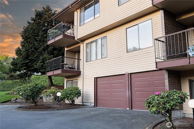 view of building exterior featuring an attached garage and driveway
