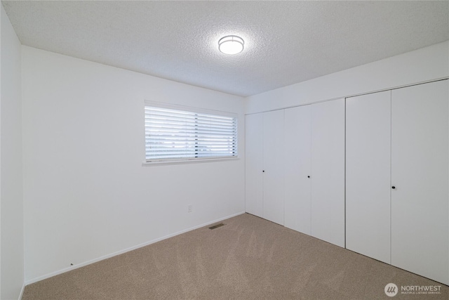 10713 Glen Acres Dr S, Seattle, WA 98168 - unfurnished bedroom with carpet flooring, a closet, a textured ceiling, and baseboards