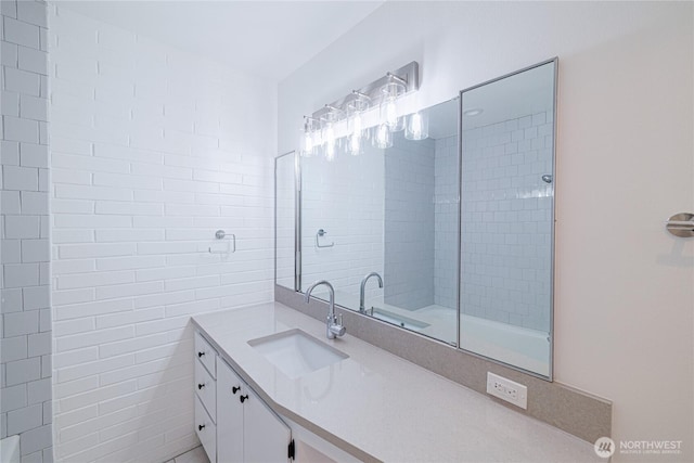 bathroom with vanity and tile walls