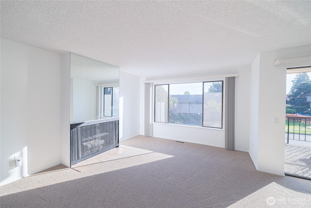 unfurnished living room featuring carpet floors and a textured ceiling
