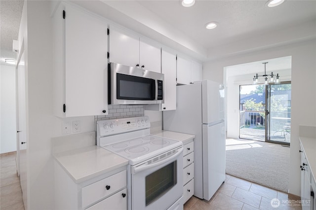 kitchen featuring white appliances, recessed lighting, light countertops, white cabinetry, and light colored carpet