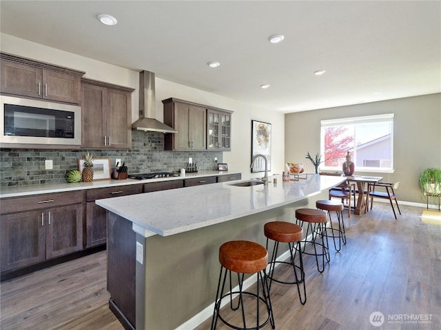 9932 15th Pl SE, Lake Stevens, WA 98258 - kitchen featuring wall chimney range hood, built in microwave, a sink, a kitchen bar, and backsplash