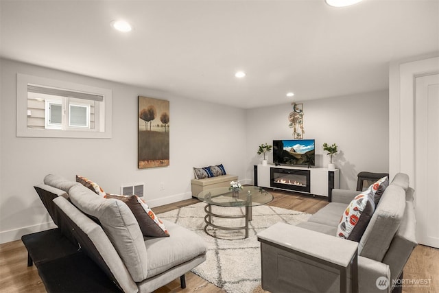 living area featuring wood finished floors, recessed lighting, and baseboards