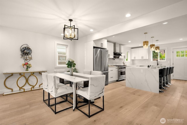 dining area with a chandelier, light wood-type flooring, and recessed lighting