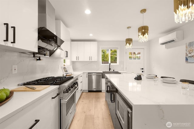 kitchen with appliances with stainless steel finishes, a wall mounted air conditioner, a sink, a chandelier, and recessed lighting