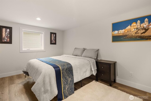 bedroom with baseboards, wood finished floors, and recessed lighting