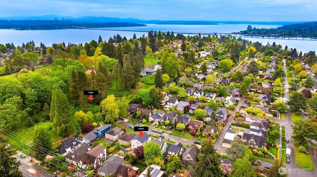 aerial view of property's location with a large body of water and nearby suburban area