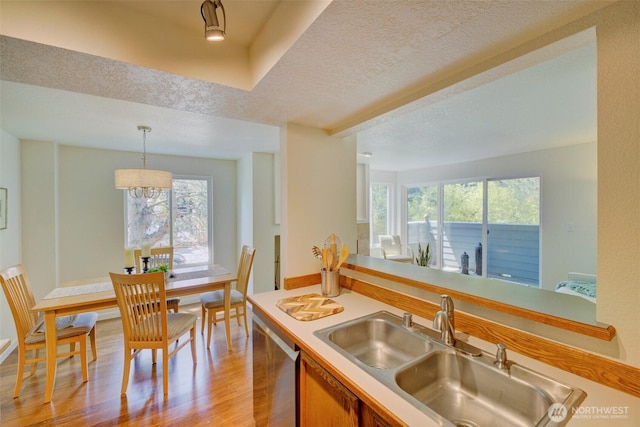 5901 Phinney Ave N Unit 103, Seattle, WA 98103 - kitchen with healthy amount of natural light, dishwasher, light wood-style floors, brown cabinetry, and a textured ceiling