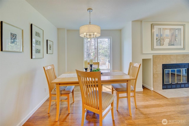 5901 Phinney Ave N Unit 103, Seattle, WA 98103 - dining space featuring light wood-type flooring, a chandelier, and a tile fireplace