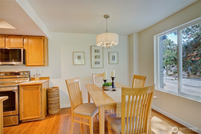 5901 Phinney Ave N Unit 103, Seattle, WA 98103 - dining room featuring light wood finished floors and a chandelier