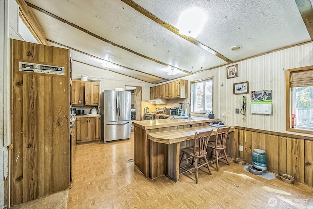 510 Duterrow Rd SE Unit 37, Olympia, WA 98513 - kitchen with freestanding refrigerator, vaulted ceiling, a peninsula, a textured ceiling, and brown cabinets