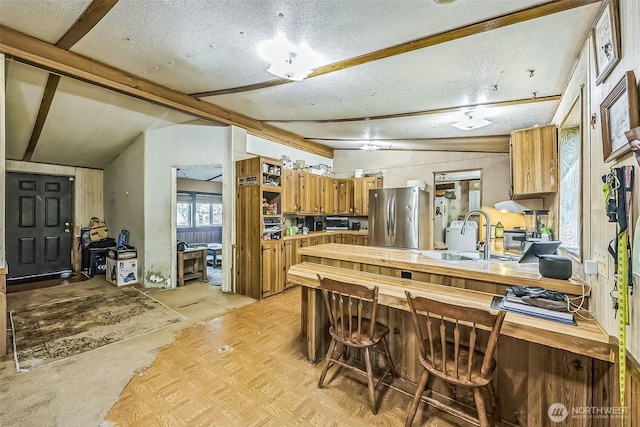 510 Duterrow Rd SE Unit 37, Olympia, WA 98513 - kitchen with freestanding refrigerator, wood counters, a peninsula, a sink, and lofted ceiling