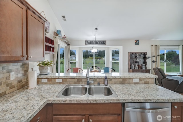48 Bennett Ln, Oakville, WA 98568 - kitchen featuring stainless steel dishwasher, a sink, brown cabinets, light countertops, and tasteful backsplash