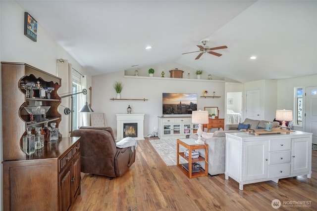 48 Bennett Ln, Oakville, WA 98568 - living room with ceiling fan, light wood-type flooring, lofted ceiling, plenty of natural light, and a glass covered fireplace