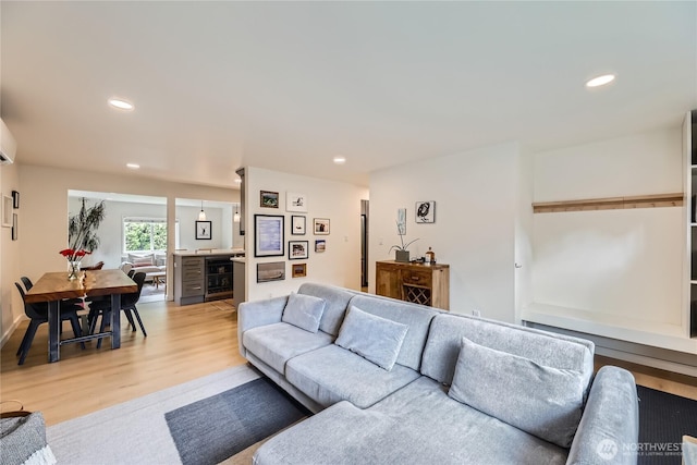living area with light wood finished floors, wine cooler, and recessed lighting