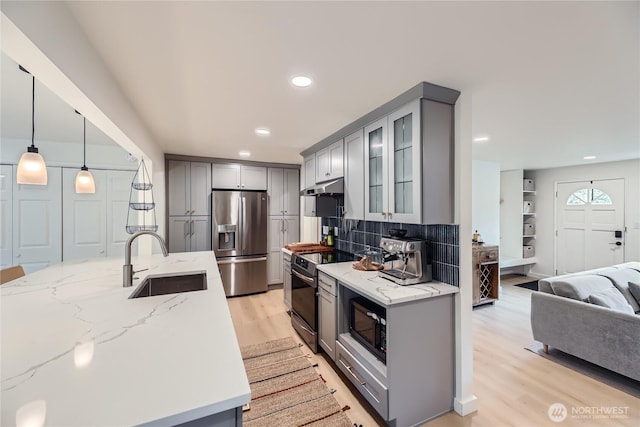 kitchen featuring stainless steel refrigerator with ice dispenser, a sink, gray cabinets, range with electric cooktop, and under cabinet range hood