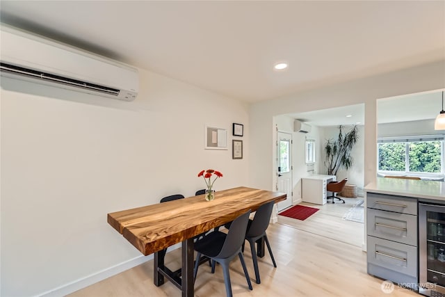 dining space featuring wine cooler, an AC wall unit, light wood-style flooring, recessed lighting, and baseboards